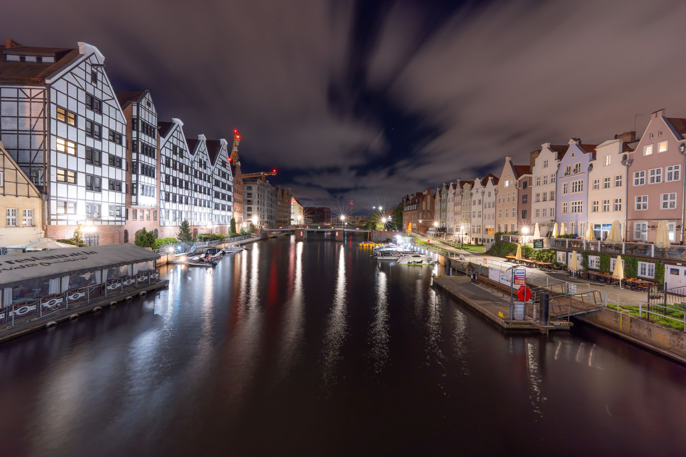 Altstadt von Danzig bei Nacht mit beleuchteten Giebelhäusern und Spiegelungen im Fluss